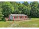 Charming single-story home with a spacious wooden deck and beautiful green yard at 2611 Dallas Stanley Hwy, Stanley, NC 28164