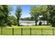 This backyard features a large manicured lawn with lake view, and black metal fence at 330 Waters Rd, Salisbury, NC 28146