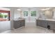 Bright bathroom featuring dual sinks, granite counters, gray cabinets, a corner tub, and neutral flooring at 330 Waters Rd, Salisbury, NC 28146