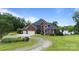 Beautiful two-story brick home with a three-car garage, lush landscaping, and a serene lakeside backdrop at 330 Waters Rd, Salisbury, NC 28146