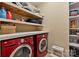 Laundry room with a vibrant red washer and dryer set, wooden shelves and storage at 330 Waters Rd, Salisbury, NC 28146
