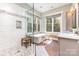 Light-filled bathroom with freestanding tub, glass enclosed shower and double windows at 4033 Hilton Lake Rd, Kannapolis, NC 28083