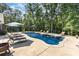 Relaxing in-ground pool surrounded by lounge chairs and a lush treeline on a sunny day at 4033 Hilton Lake Rd, Kannapolis, NC 28083