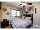 Comfortable bedroom featuring a bed, a ceiling fan, and a window for natural light at 6421 Hidden Forest Dr, Charlotte, NC 28213