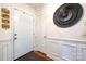 Inviting entryway featuring fresh paint, classic wainscoting, wood floors, and a door with a half-moon window at 6421 Hidden Forest Dr, Charlotte, NC 28213