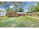 Charming brick home featuring a well-manicured lawn, colorful landscaping, and complementary colored shutters and front door at 6421 Hidden Forest Dr, Charlotte, NC 28213