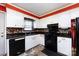 Functional kitchen with classic white cabinets, black appliances, and a patterned backsplash at 6421 Hidden Forest Dr, Charlotte, NC 28213