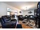 Open-concept living room featuring wood floors, a modern lighting fixture, and direct access to the kitchen and dining area at 6421 Hidden Forest Dr, Charlotte, NC 28213