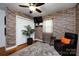 Living room with a decorative stone wall, hardwood floors, and comfortable chair at 6421 Hidden Forest Dr, Charlotte, NC 28213