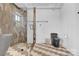 Modern bathroom features a walk-in shower with a stone base, stone tile walls, sleek black toilet, and hexagon tile flooring at 715 N Graham St # 207, Charlotte, NC 28202