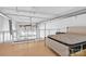 Modern bedroom with hardwood floors, a stylish bed, exposed ductwork, and bright natural light, ideal for urban living at 715 N Graham St # 207, Charlotte, NC 28202