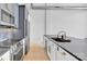 Open kitchen with stainless steel appliances, dark countertops, and white and gray cabinets at 715 N Graham St # 207, Charlotte, NC 28202