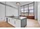 Modern kitchen features a spacious island, stainless steel appliances, and large industrial windows at 715 N Graham St # 207, Charlotte, NC 28202