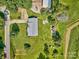 Expansive aerial view of a well-maintained property with a brick home, lush lawns, and firepit at 7753 Caswell Rd, Stanley, NC 28164