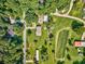 Sprawling property featuring a brick home, lush lawns, additional structures, and surrounding trees at 7753 Caswell Rd, Stanley, NC 28164