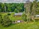Aerial view of a brick home surrounded by lush greenery, featuring a shed, and spacious yard at 7753 Caswell Rd, Stanley, NC 28164