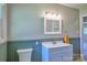Well-lit bathroom featuring a white vanity, framed mirror, and beadboard trim along the walls at 7753 Caswell Rd, Stanley, NC 28164