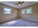 Carpeted bedroom featuring a ceiling fan and two windows providing natural light at 7753 Caswell Rd, Stanley, NC 28164