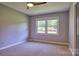 Neutral bedroom featuring a ceiling fan and a window overlooking the front yard at 7753 Caswell Rd, Stanley, NC 28164