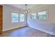 Bright dining room with three windows and wood-look laminate flooring at 7753 Caswell Rd, Stanley, NC 28164