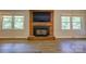 Close-up of the Craft Stove fireplace, flanked by windows, providing a cozy focal point at 7753 Caswell Rd, Stanley, NC 28164