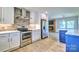 Bright kitchen features white cabinets, stainless steel appliances, and an open floor plan at 7753 Caswell Rd, Stanley, NC 28164