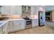 Updated kitchen with white cabinets, stainless steel appliances and brick backsplash at 7753 Caswell Rd, Stanley, NC 28164