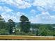 Scenic lake view from a wooden deck with lush greenery and clear blue skies and puffy clouds at 114 Joe Teague Rd, Hickory, NC 28601
