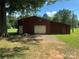 Large outbuilding with a garage door and ample storage space, surrounded by a grassy yard at 12003 Old Beatty Ford Rd, Rockwell, NC 28138