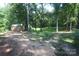 View of the backyard, featuring mature trees, and a wooden shed with firepit area at 1257 Reese Roach Rd, Rock Hill, SC 29730