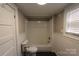Clean, white bathroom with shower-tub combo and wainscotting halfway up the wall at 1257 Reese Roach Rd, Rock Hill, SC 29730