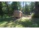 Backyard view with a wooden storage building and smaller outbuilding in a wooded lot at 1257 Reese Roach Rd, Rock Hill, SC 29730