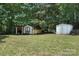 Spacious backyard featuring mature trees and three sheds at 222 Laramie Dr, Stanley, NC 28164