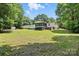Property featuring spacious backyard, screened porch, and adjacent storage buildings at 222 Laramie Dr, Stanley, NC 28164