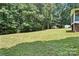 Spacious backyard featuring mature trees, a shed, and an open grassy area at 222 Laramie Dr, Stanley, NC 28164
