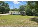House backyard featuring spacious lawn, screened porch, and lots of shade at 222 Laramie Dr, Stanley, NC 28164