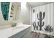 Bright bathroom featuring a cactus shower curtain, floating shelves, and a modern vanity at 222 Laramie Dr, Stanley, NC 28164