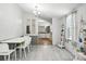 Cozy dining space with light gray wood flooring leading to an open kitchen area at 222 Laramie Dr, Stanley, NC 28164