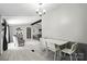 Inviting dining area featuring light gray wood floors, a white table, and a modern chandelier at 222 Laramie Dr, Stanley, NC 28164