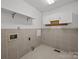 Practical laundry room featuring tiled walls, shelving, and utility connections at 2680 Heavens Ct, Fort Mill, SC 29715