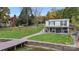 Backyard view of home with a dock, grassy lawn, covered patio, and mature trees, perfect for outdoor enjoyment at 287 Ben Eller Ln, Taylorsville, NC 28681
