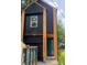Striking modern exterior with dark siding, natural wood accents, and a bright blue front door at 3049 Reid Ave, Charlotte, NC 28208