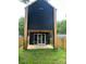 The rear exterior of the house showcases its dark siding, wood accents, and outdoor patio at 3049 Reid Ave, Charlotte, NC 28208