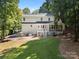 Expansive backyard of white two story home features a patio and screened in porch surrounded by lush green trees at 480 Robinson Rd, Mooresville, NC 28117