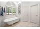 Bathroom featuring a clawfoot tub, tile floors, and a shuttered window at 480 Robinson Rd, Mooresville, NC 28117