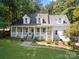 Charming white house with a welcoming front porch and beautifully landscaped front yard at 480 Robinson Rd, Mooresville, NC 28117