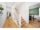 Bright hallway featuring hardwood floors, a staircase with white banisters, and a view into an adjacent dining room at 480 Robinson Rd, Mooresville, NC 28117