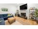Cozy living room with fireplace, hardwood floors, a comfortable blue sofa, and stylish decor at 480 Robinson Rd, Mooresville, NC 28117