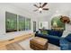 Inviting living room featuring large windows, a plush blue sectional sofa, and views of the screened-in porch at 480 Robinson Rd, Mooresville, NC 28117