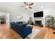 Well-lit living room boasting hardwood floors, a cozy blue sofa, a fireplace, and decorative shelving units at 480 Robinson Rd, Mooresville, NC 28117
